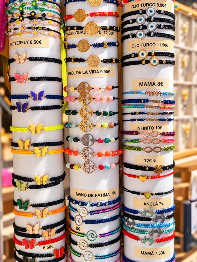 Expositor de pulseras artesanales hechas a mano en Da Vinci Santillana, con diseños de macramé, piedras y abalorios.