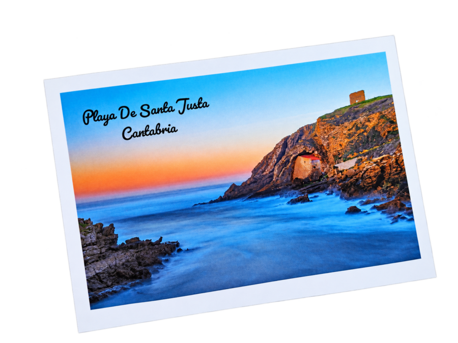 Postal de la Playa de Santa Justa en Ubiarco, Cantabria, con su ermita entre los acantilados y el mar Cantábrico al atardecer